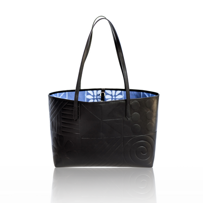 Black leather tote bag featuring Afro-modern Adire motifs, symbolizing cultural heritage and contemporary elegance. Crafted from full-grain Italian leather with vibrant Adire fabric lining. Choose from three colorful variations. Egba Ake